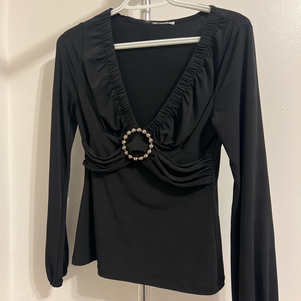 Black long sleeve with a plunging neckline and jewel detailing.